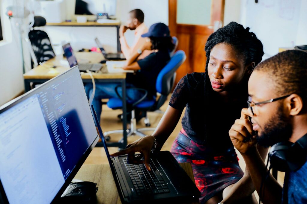 Two colleagues reviewing dashboards on screen
